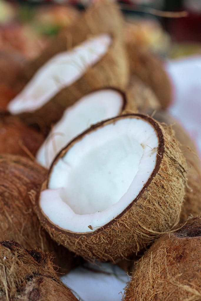 Sliced open coconuts with fresh white meat visible, perfect for tropical themes.