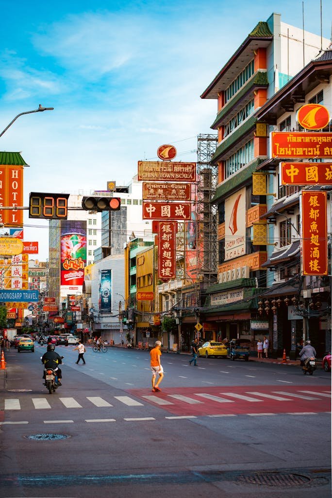 A lively street scene from Chinatown, Bangkok showcasing cultural signs and urban life.