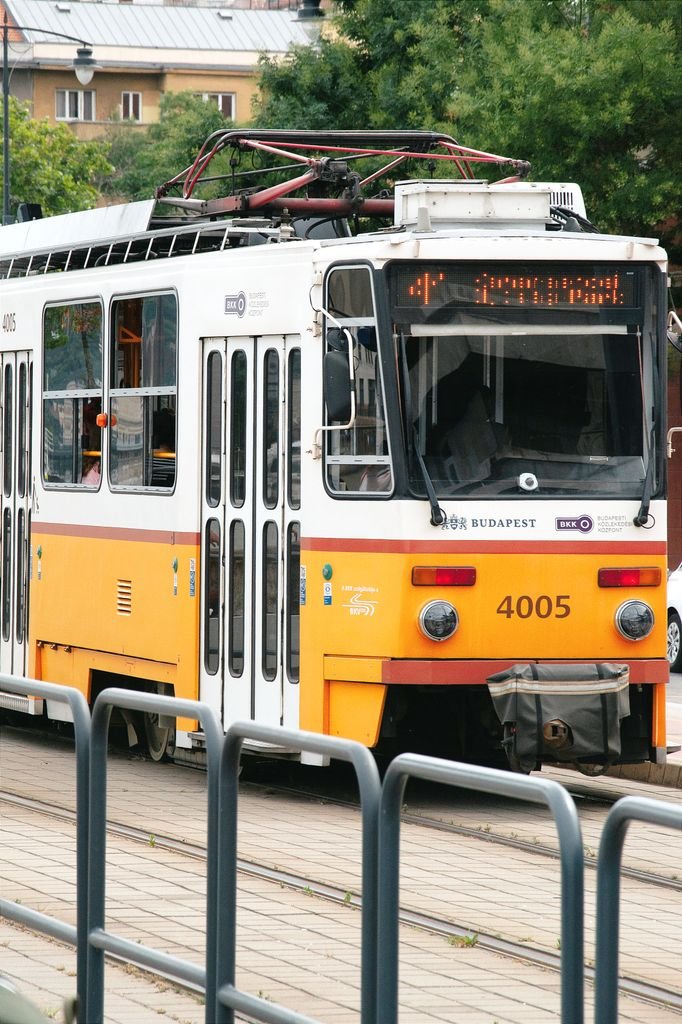 A yellow tram in Budapest, Hungary, captures urban life and public transport.