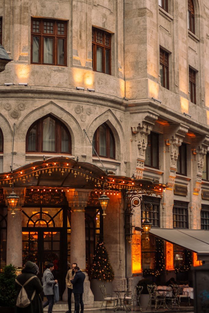 Beautiful old building with warm lights and festive decorations in an urban setting.
