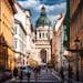 Bustling street view leading to the iconic St. Stephen's Basilica in vibrant Budapest on a sunny day.