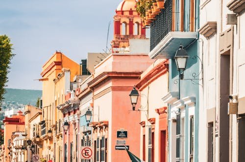 Colorful colonial architecture with people and Mexican flag in Santiago de Querétaro.