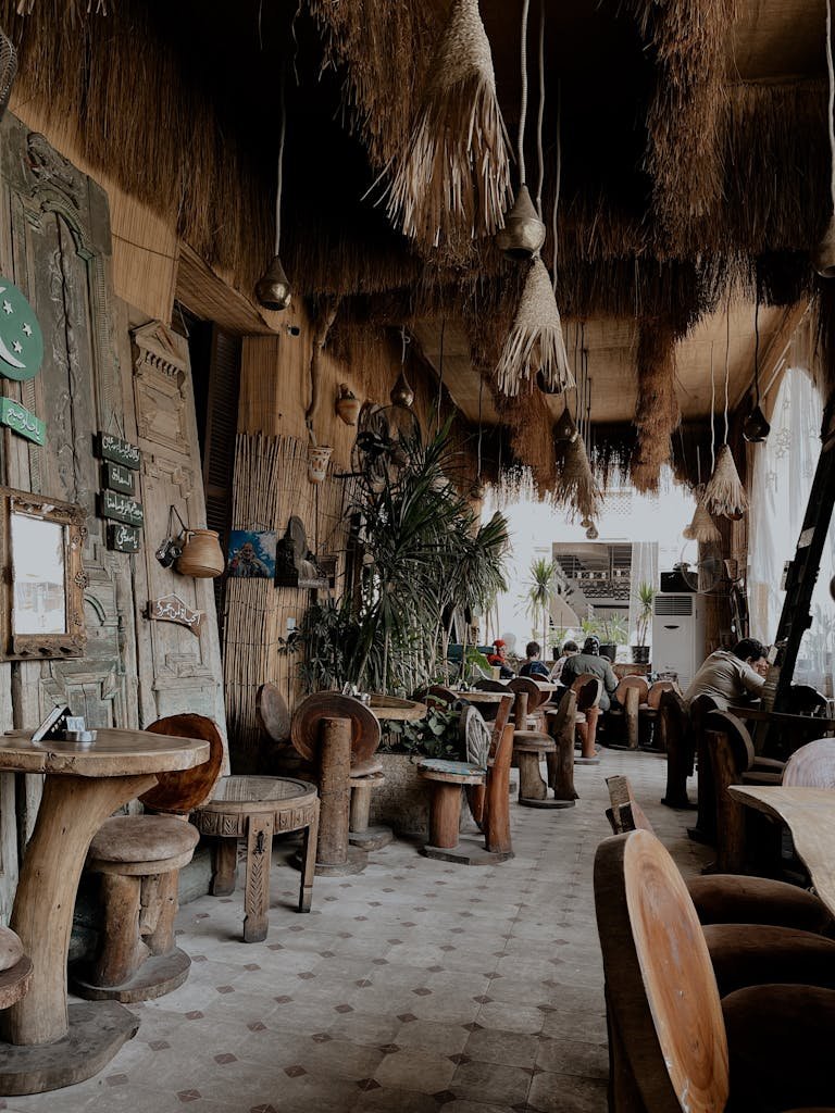 Cozy cafe interior with wooden furniture, unique decorations, and indoor plants providing a rustic vibe.