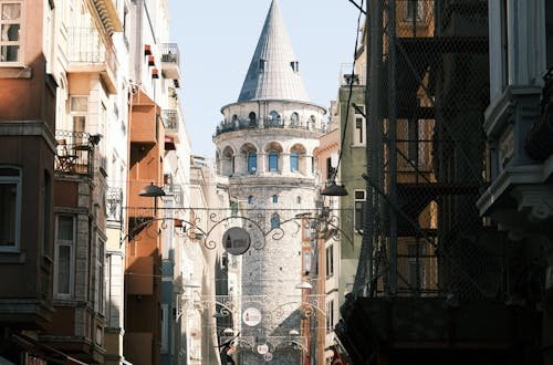 Crowded street view towards the historic Galata Tower in Istanbul, showcasing vibrant urban life.