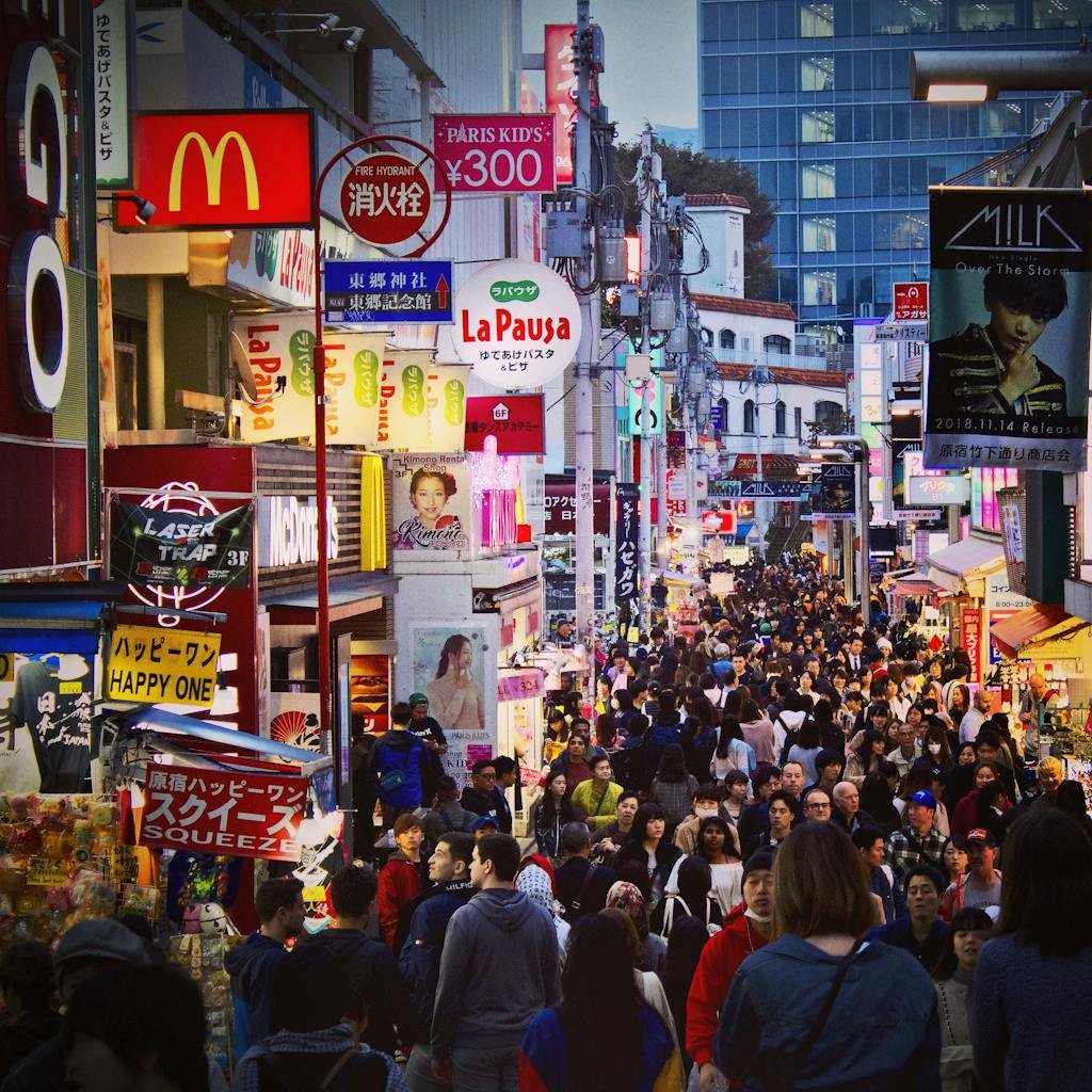 Crowded Takeshita Street in Tokyo filled with vibrant shops and signage during twilight.