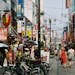 Explore the bustling atmosphere of a vibrant street in Japan, displaying daily life and local culture.