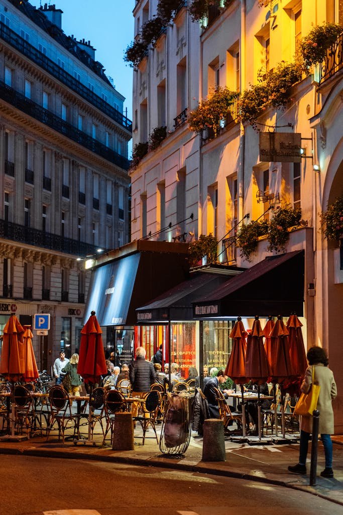 Outdoor cafe in Paris at dusk, capturing vibrant street life and architecture.