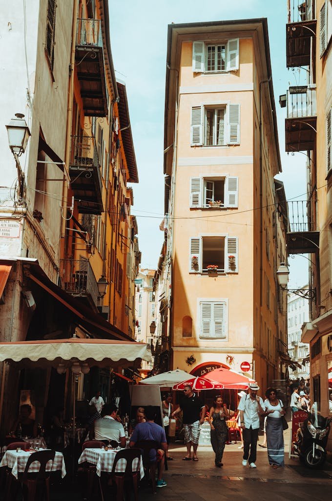 Quaint street scene in Nice, showcasing lively cafes and historic architecture.