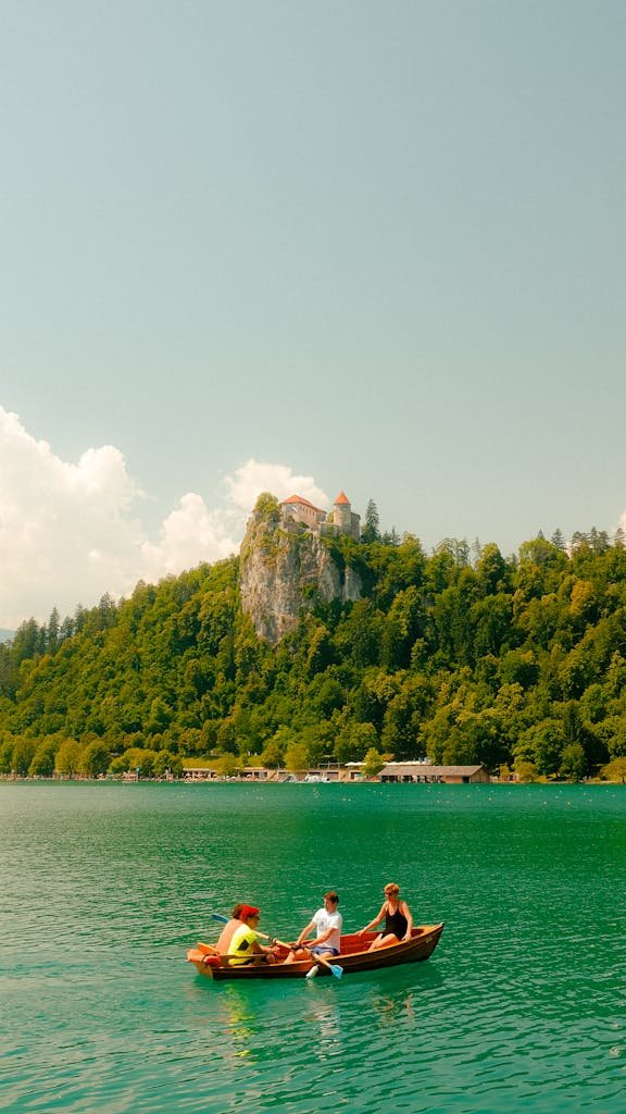 Scenic view of Lake Bled with tourists boating under the iconic Bled Castle in Slovenia.