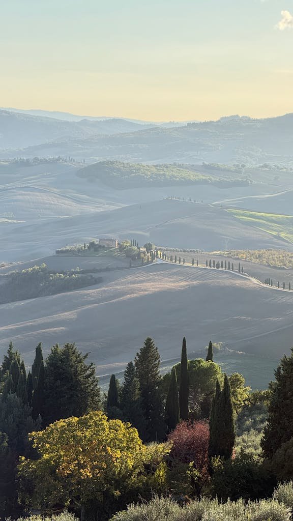 Scenic view of Tuscany's rolling hills and countryside at sunset, showcasing nature's beauty.