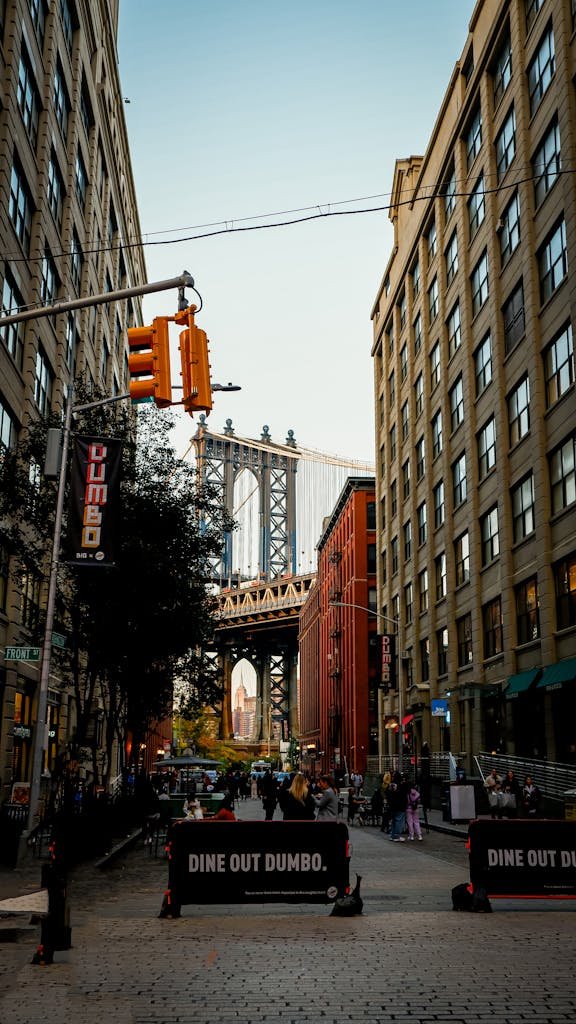 Street view capturing Manhattan Bridge from Washington Street in New York's Dumbo neighborhood, featuring urban architecture.
