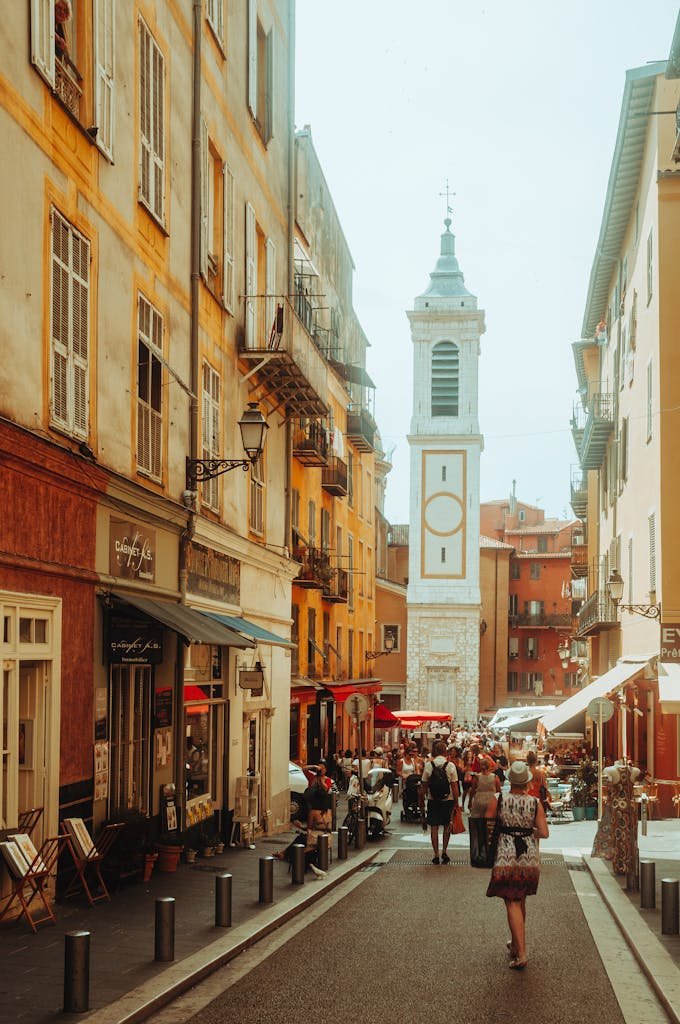 Stroll through a vibrant European street lined with historic buildings and a distant church tower.