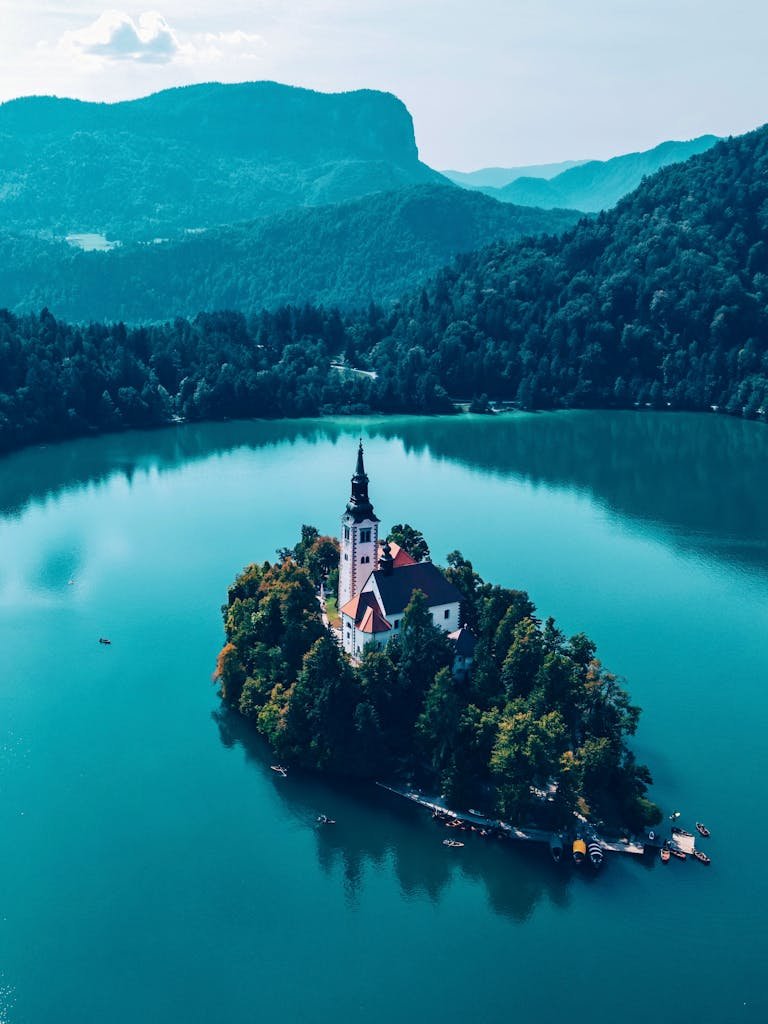 Stunning aerial shot of Bled Island with its iconic church surrounded by turquoise lake.