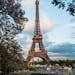 The iconic Eiffel Tower seen through blooming trees on a lovely spring day in Paris.