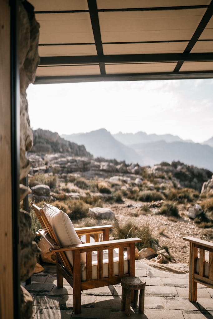 Tranquil outdoor seating area with armchairs overlooking a mountainous landscape.