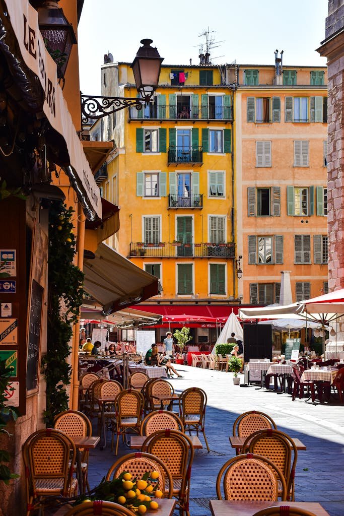Vibrant and charming street view of Nice, France featuring colorful architecture and outdoor cafes.