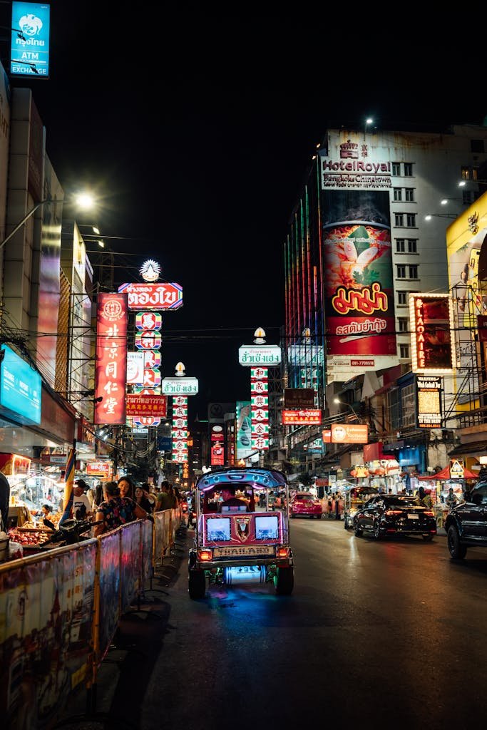 Vibrant night street scene in Bangkok's Chinatown featuring colorful neon signs and bustling activity.