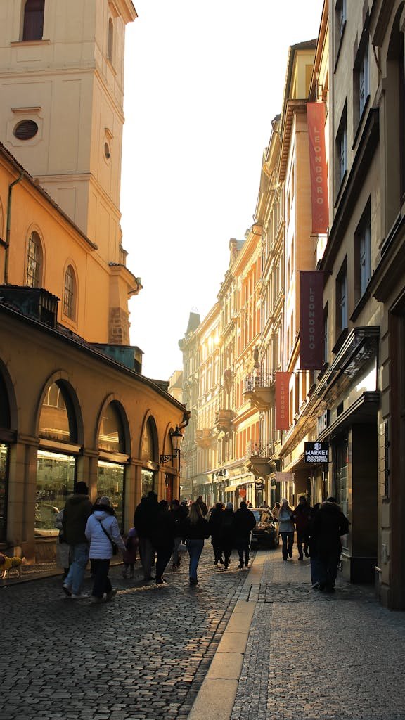 A charming cobblestone street in Prague lit warmly at dusk, capturing the city's historic architecture and vibrant ambiance.