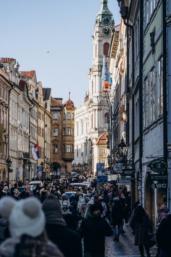 A lively street scene with historic architecture in a European city filled with pedestrians.