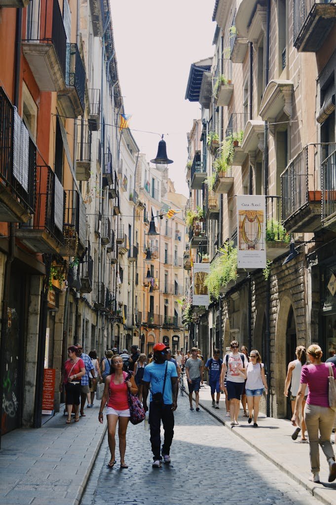 Bustling old European city street with people walking and historic architecture.