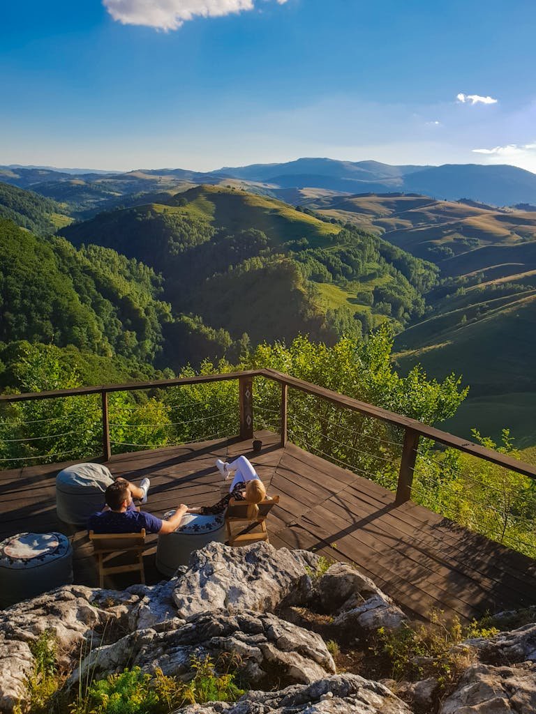 Couple enjoying a tranquil view of Alba's rolling hills from a wooden deck.